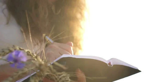 Female hands with pen writing on notebook on grass outside Stock Footage 65421663