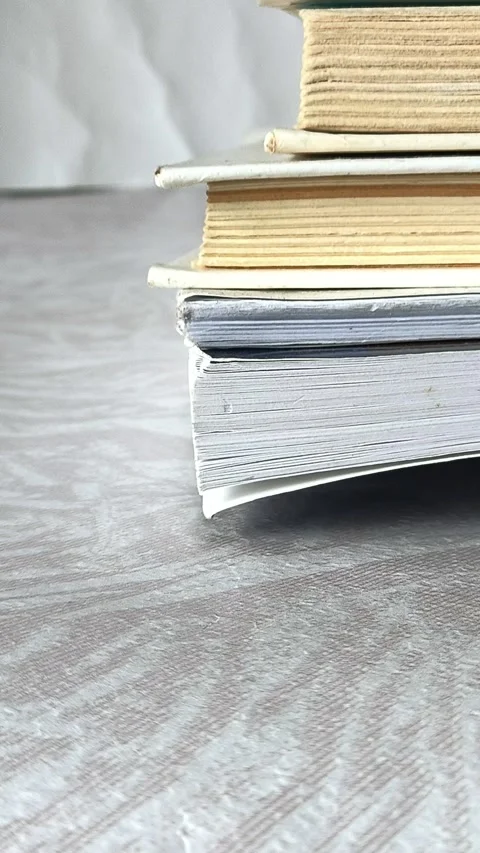 Female hands place a stack of books on the table. Stock Footage 313978096