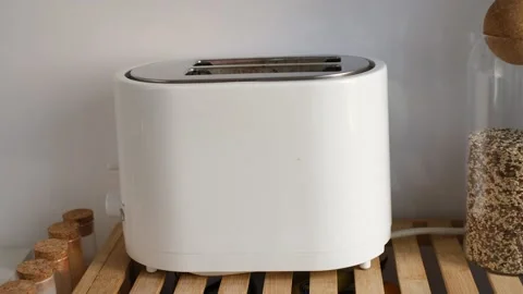 Female hands placing bread into a toaster and turning it on Stock Footage 321195887