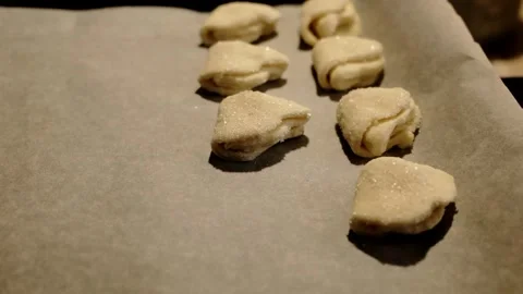 Female hands placing raw cookie dough pieces on a baking tray lined with Stock Footage 316617853