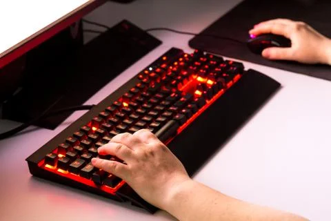 Female hands playing computer game with gaming gear. Stock Photos