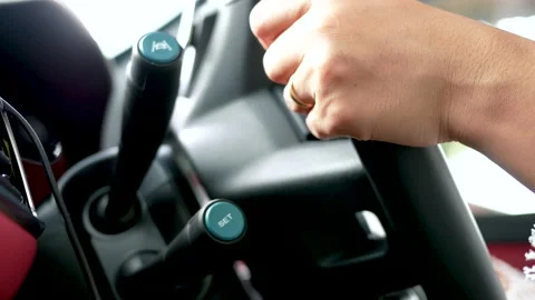 Female hands pressing the button the adaptive Cruise Control while driving a car Stock Footage 143761787