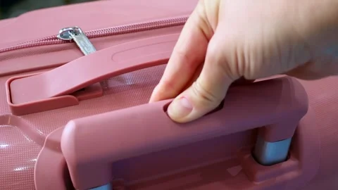 Female hands pressing the button and pushing the luggage handle close up Stock Footage 265248140
