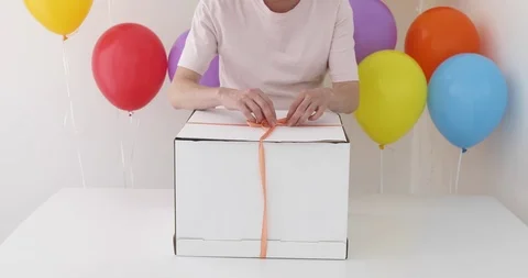 Female hands pulling a red ribbon to open gift box Stock-Footage 92193945