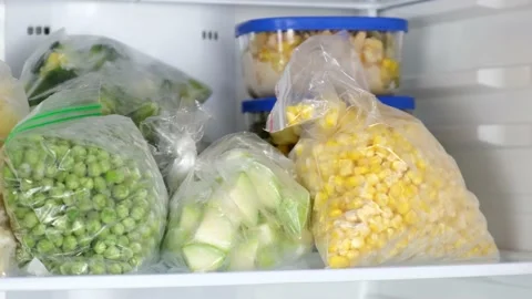 Female Hands pulls frozen corn out of the fridge Stock Footage 145832652