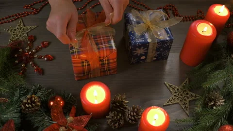 Female hands put and finalize Christmas gift on a wooden table. Stock Footage 144936667