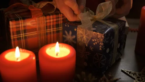 Female hands put and finalize Christmas gift on a table decorated with Christmas Stock Footage 165436491