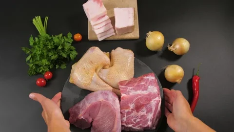 Female hands put on a background of a stone plate with pieces of raw meat Stock-Footage 194038800