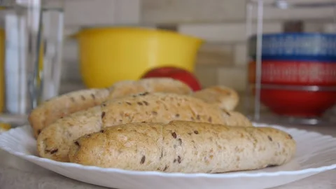 Female hands put bran bread on a dish and take the dish from the table Stock Footage 131761009