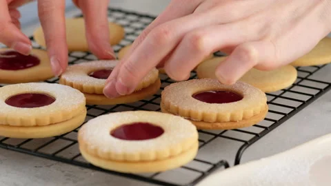 Female hands put cookies on the second cookie with jam. Female hands a making Stock Footage 145364445