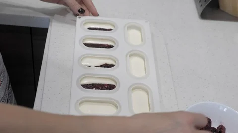 Female hands put in a form, with white cream, sticks of frozen berries, close-up Stock Footage 126316016