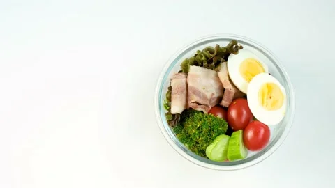 Female hands put glass boxes with food on the table close-up top view on a white Stock Footage 237651158