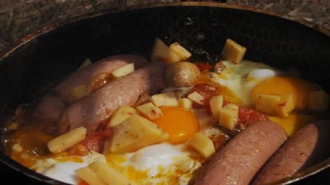 Female hands put pieces of egg cheese in a frying pan with tomatoes 库存影片 204871753