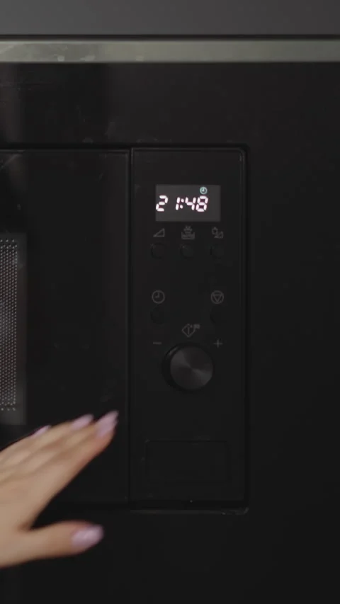 Female hands put plate with dish in built-in microwave oven Video stock 295690159
