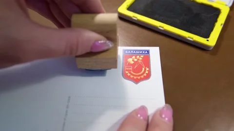 Female hands put a stamp on a postcard Stock Footage 226791815