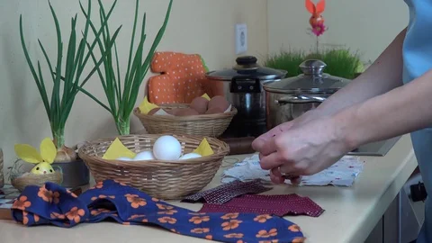 Female hands put white egg into silk material. Easter eggs painting. Stock Footage