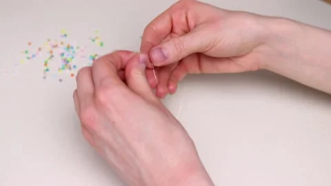 Female hands puts multicolored beads on a fishing line Stock Footage 197603178