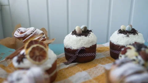 Female hands putting Easter cakes creatively decorated with white icing, candied Stock Footage 236889028