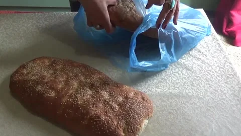 Female hands putting flat bread from a bag on the table Stock Footage 307384150
