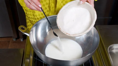 Female hands putting sugar in hot milk while preparing dough for muffins Stock Footage 153528126