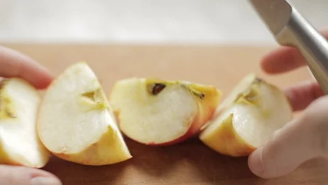 Female hands rearrange apple slices on a cutting board Stock Footage