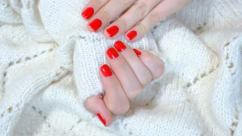 Female hands with red manicure isolated on knitted background. Video stock 221456891