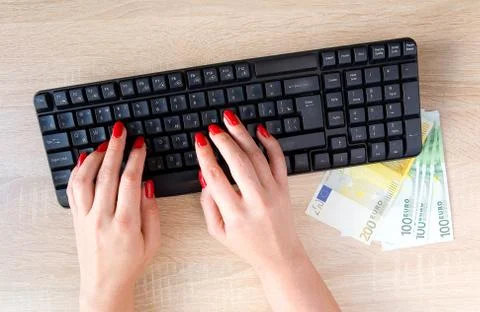 Female hands with red nails on a computer keyboard. Foto stock
