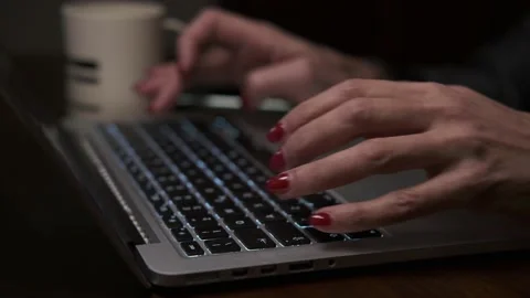 Female hands with red nails typing on laptop keyboard, side view. Vídeo Stock 148247684