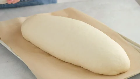 Female hands remove the towel from the dough on a light table for making wheat Stock Footage 146141459