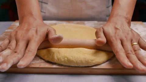 Female hands roll out the dough with a rolling pin preparing the dough for pizza Vidéo 158092322