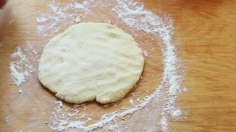 Female hands rolling dough with rolling pin for pastry on wooden table Stock Footage 107523356