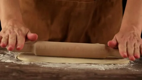 Female hands rolling out dough with a rolling pin Stock Footage 255130815