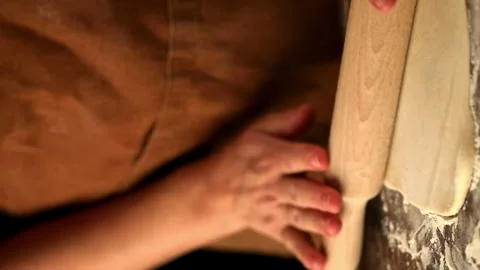 Female hands rolling out dough with a rolling pin Stock Footage 255663675