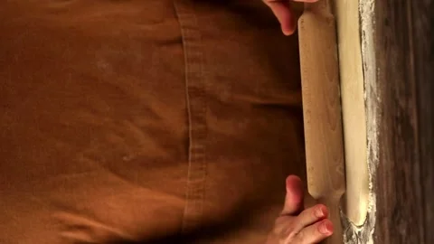 Female hands rolling out dough with a rolling pin Stock Footage 255663676