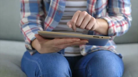 Female hands scrolling digital tablet on sofa Stock Footage 54778450