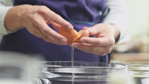 Female hands separate the egg white from the yolk over a glass bowl. Stock Footage 159908153