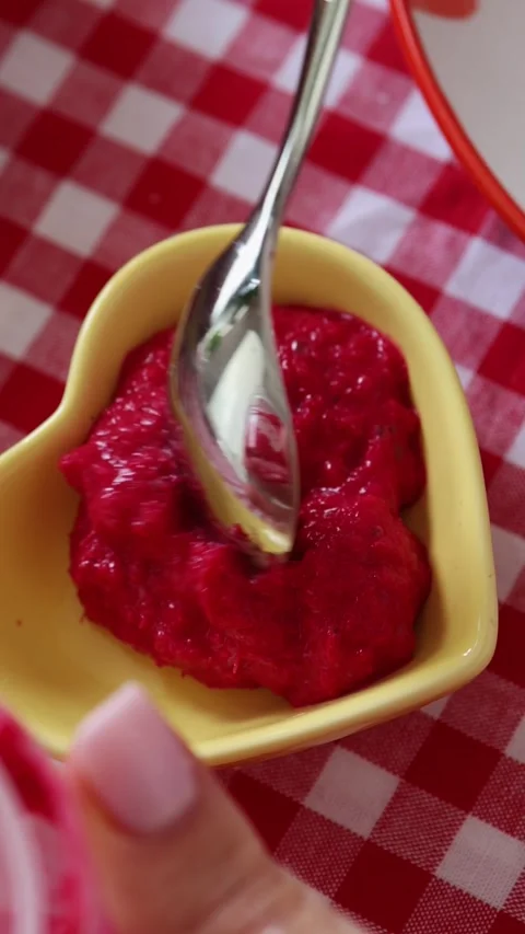 Female hands serve red beetroot horseradish into a yellow plate Stock Footage 306151462