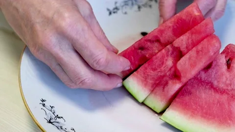 Female hands serving triangular slices of ripe juicy watermelon on white plate 스톡 동영상 213189667