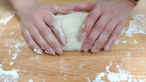Female hands shaping some bread dough into a loaf shape. It's done on top Stock Footage 129234701