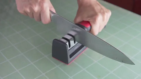 Female hands sharpening a knife in a kitchen Video stock 293113795