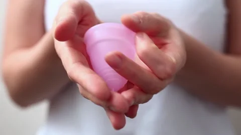 Female hands show using menstrual cup. Woman hand holding menstrual cup. Female Stock Footage 167290221
