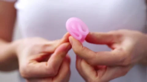 Female hands show using menstrual cup close up. Woman hand holding menstrual cup Stock Footage 167549623