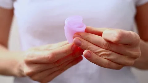 Female hands show using menstrual cup. Woman hand holding menstrual cup. Female Stock Footage 169087199