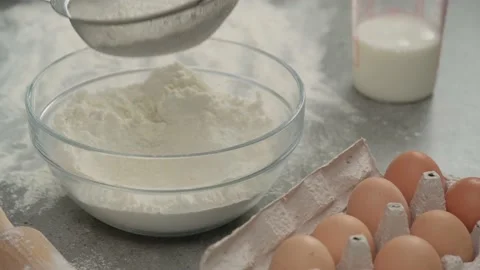 Female hands sift flour through a sieve into a glass bowl Stock-Footage 133441902