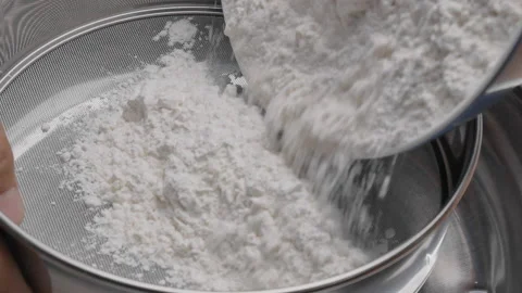 Female hands sifting flour with filter into a container to make pizza dough. Видео 158664780