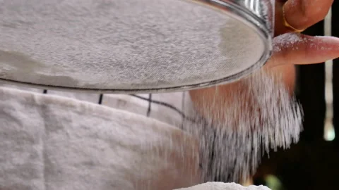 Female hands sifting flour with filter into a container to make pizza dough. Stockbeeldmateriaal 158665531