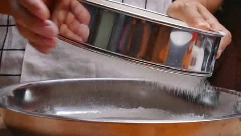 Female hands sifting flour with filter into a container to make pizza dough. Stockbeeldmateriaal 158665659