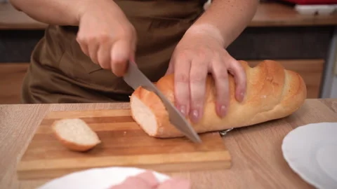 Female hands Sliced wheat Bread on wooden kitchen board. Texture of baked bread Stock Footage 316976385