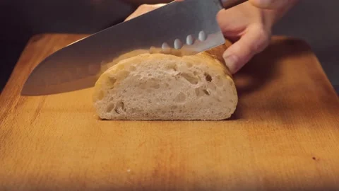 Female hands slicing white bread. Woman cutting bread with knife Stock Footage 144672032