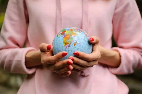 Female hands with a small globe with Ukrainian names and Cyrillic letters on it Stock Photos